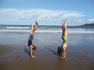two women standing on hands at the seashore