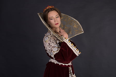 woman wearing maroon and white medieval dress against black background