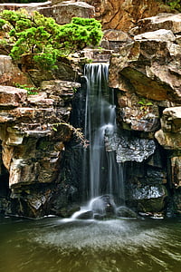 waterfalls surrounded by brown rocks