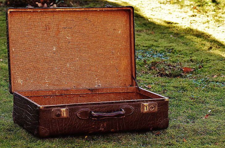 Brown vintage leather suitcase on a wooden deck lying flat viewed
