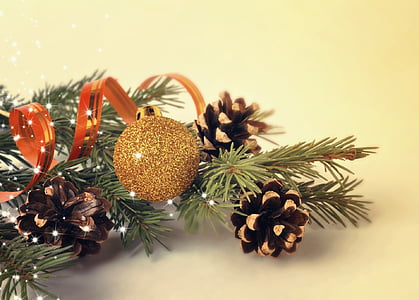 closeup photo of a gold bauble hanging on lit tree