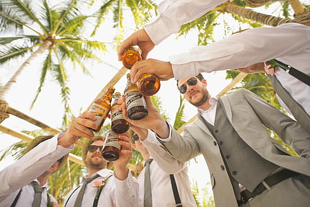 group of men holding beer bottles