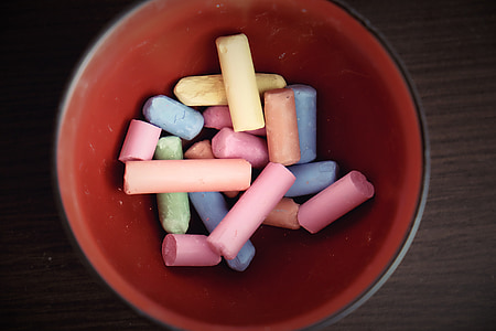 assorted-color chalks on red bowl