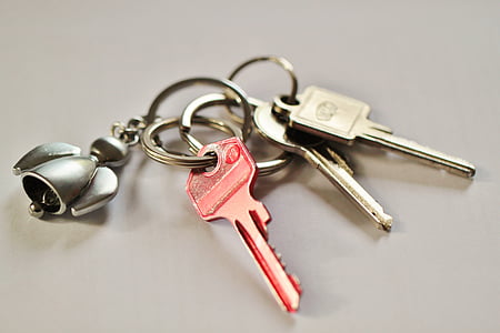 three pink and gray keys with keychain