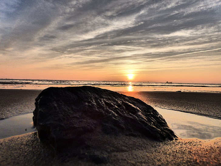 rock on beach shore during golden hour