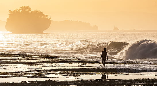 silhouette man walking on seashore during daytime