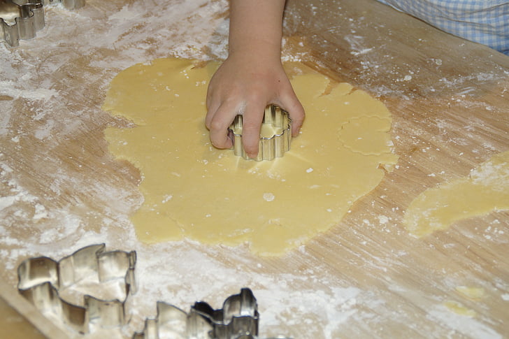 person holding gray dough cutter