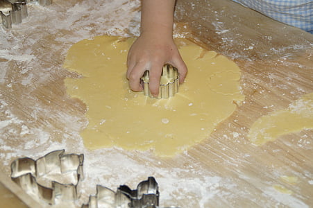 person holding gray dough cutter