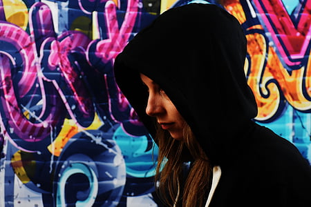 woman wearing hoodie with graffiti background
