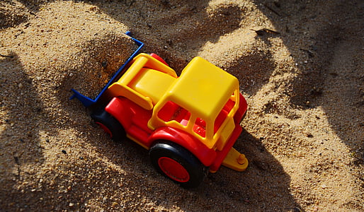yellow, red, and black plastic pay loader toy