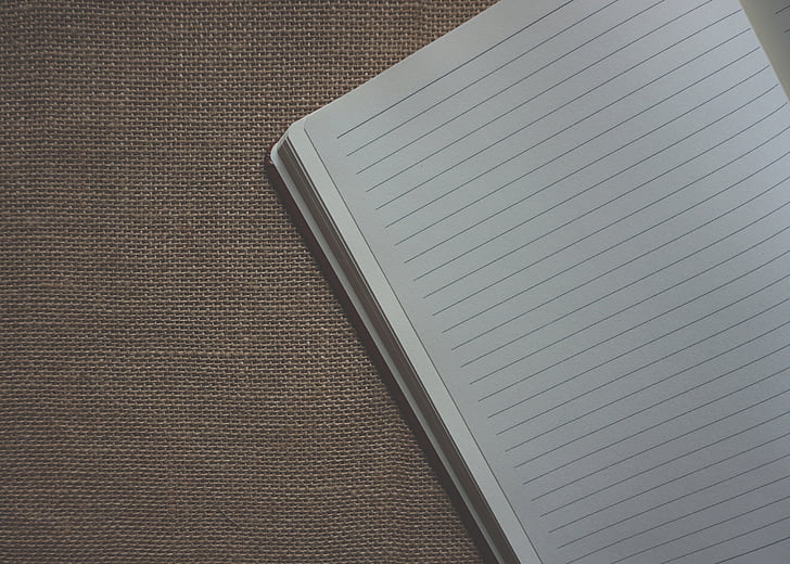 white notebook on brown surfac