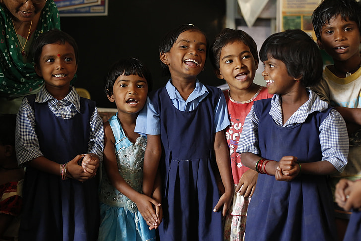 children wearing school uniform making smiling face