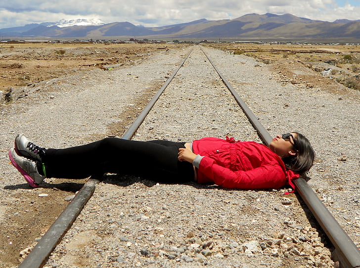 woman laying on train rail