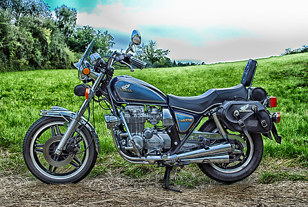 blue and black Honda cruiser motorcycle parked on green grass