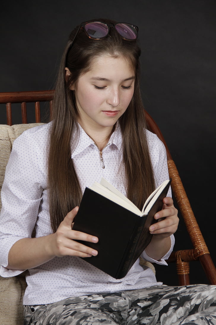 woman wearing pink collared elbow-sleeved shirt reading book