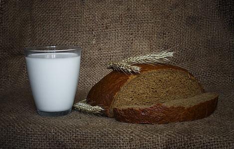 milk filled glass beside sliced bread