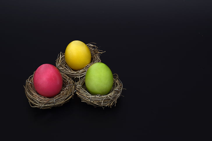 three yellow, green, and pink eggs