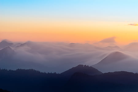 silhouette of mountains under blue and orange sky during sunset