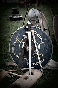 black handled sword with blue shield behind