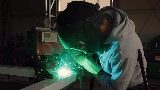 man in gray hoodie doing welding