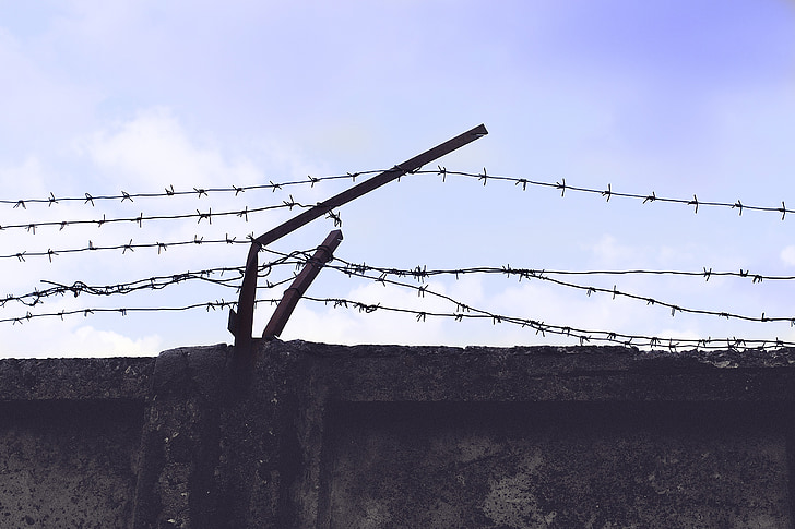 high angle photography of concrete wall with barbed wire