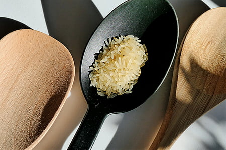 rice grains on black spoon