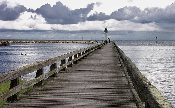 empty brown wooden dock bridge with lighthouse tower