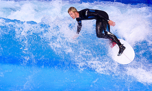 man wearing steamer wetsuit surfing using white surfboard