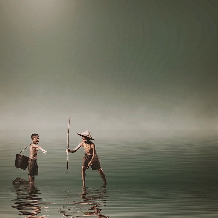 two boys catching fish on beach