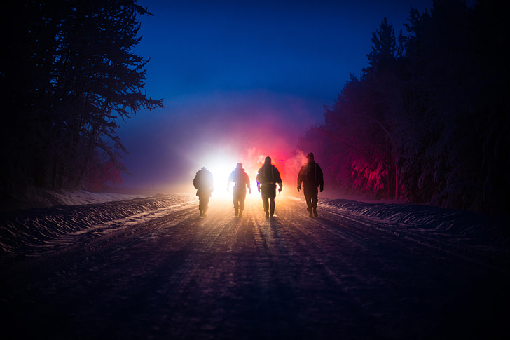 silhouette of 4 persons walking in road