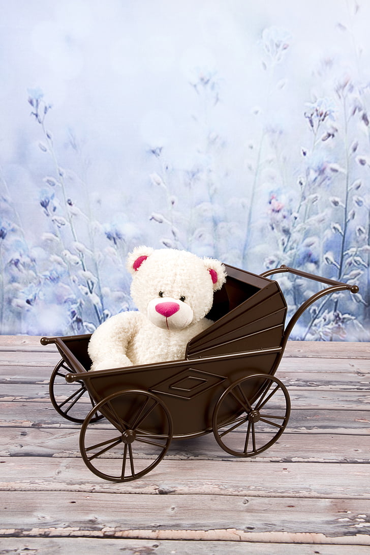 white bear plush toy on brown steel stroller