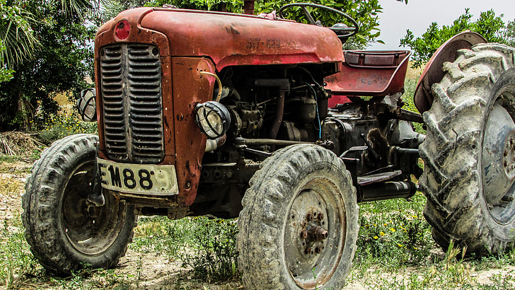 Royalty-Free photo: Red tractor on green grass field | PickPik