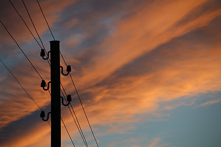 silhouette of utility pole with cbales