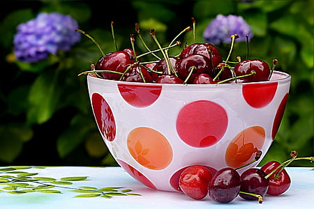 cherries in round white and red polka-dot glass bowl