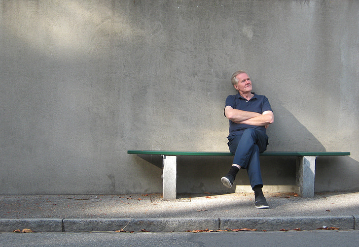 man in polo shirt sitting on bench