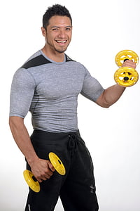 man wearing grey crew-neck shirt holding yellow and black dumbbells