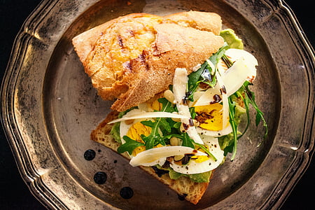 toasted bread with sliced egg and fresh vegetables on copper-colored plate