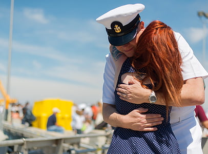 woman captain hugging woman in blue and white polka-dot dress