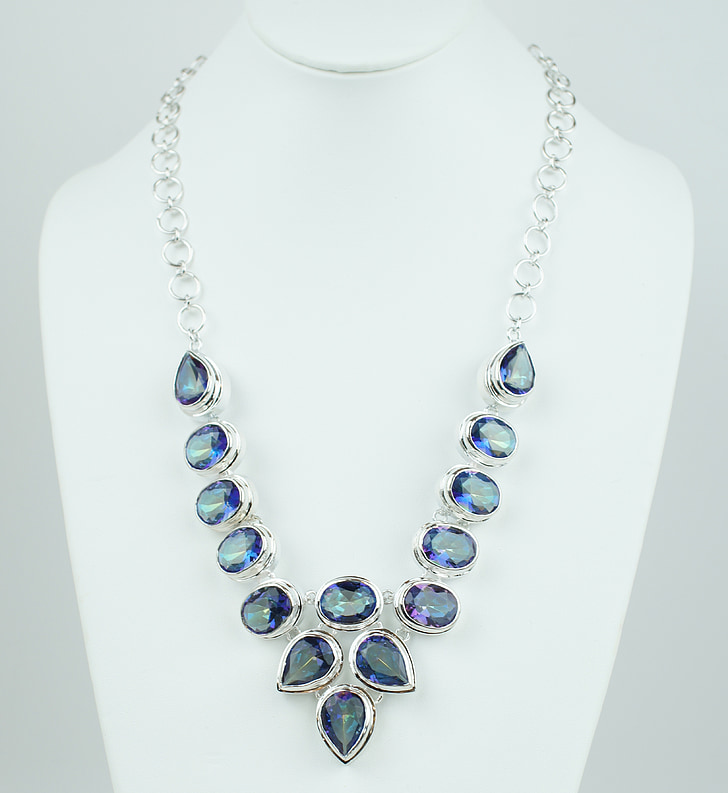 women's silver-colored necklace with blue gemstones