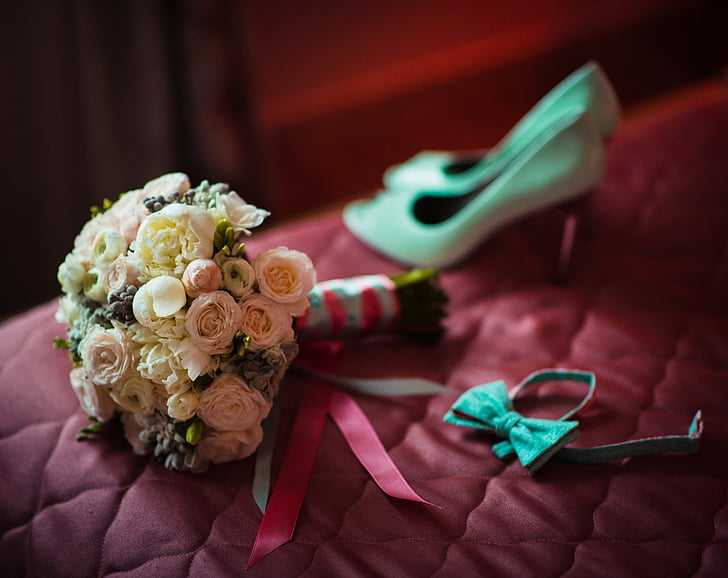 white and pink rose boquet beside teal bow tie and pair or white pumps