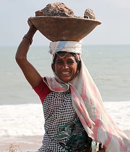 woman carrying bowl of stones