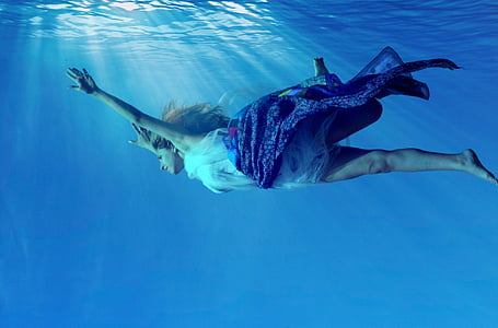 woman wearing white and maroon dress swimming