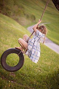 girl riding on black wheel swing