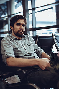 sitting man wearing gray chambray long-sleeved shirt