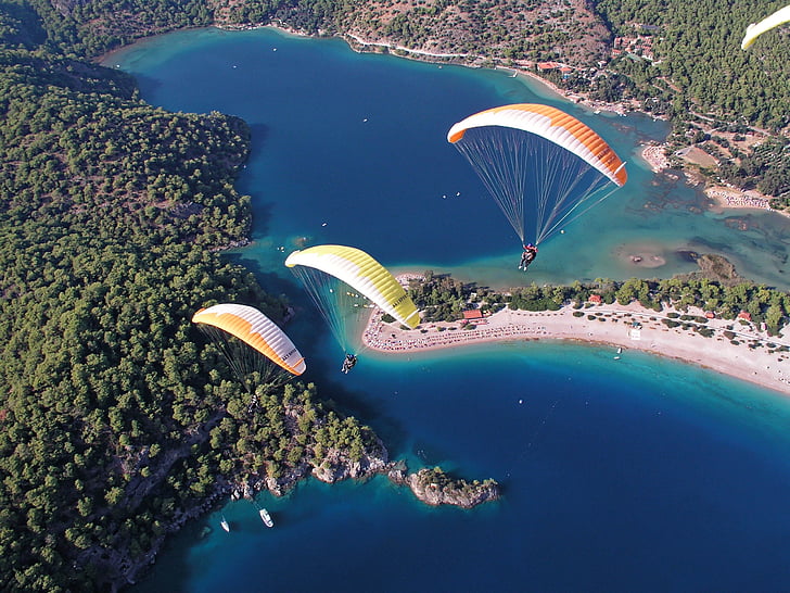 three people riding a parachute