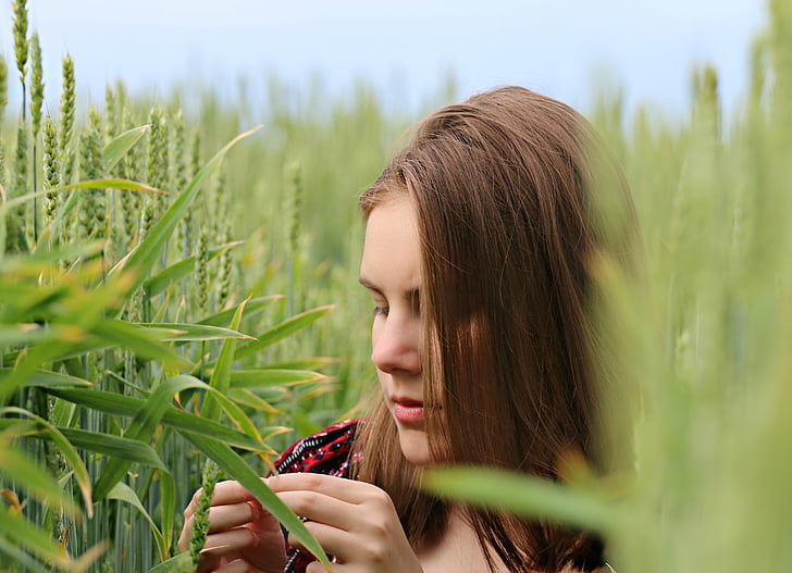 woman holding grain in middle of field