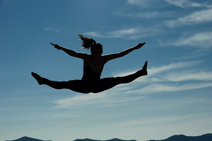 silhouette photography of woman jumping at daytime