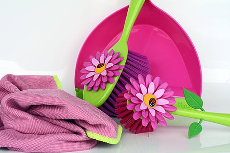 two pink and green hair brushes near pink textile