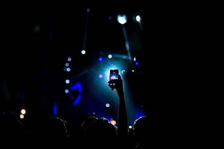 person taking a video of concert