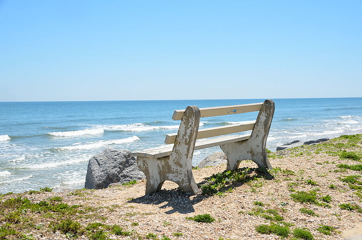 photography of bench on beach shore